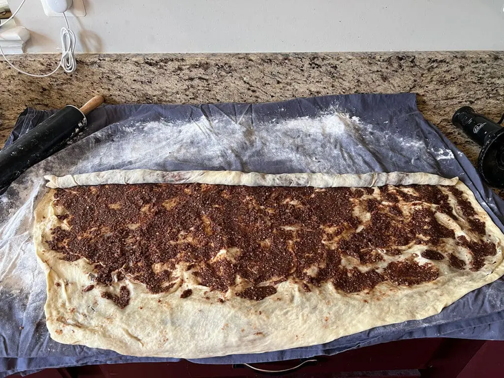 Povitica dough with filling on bed sheet