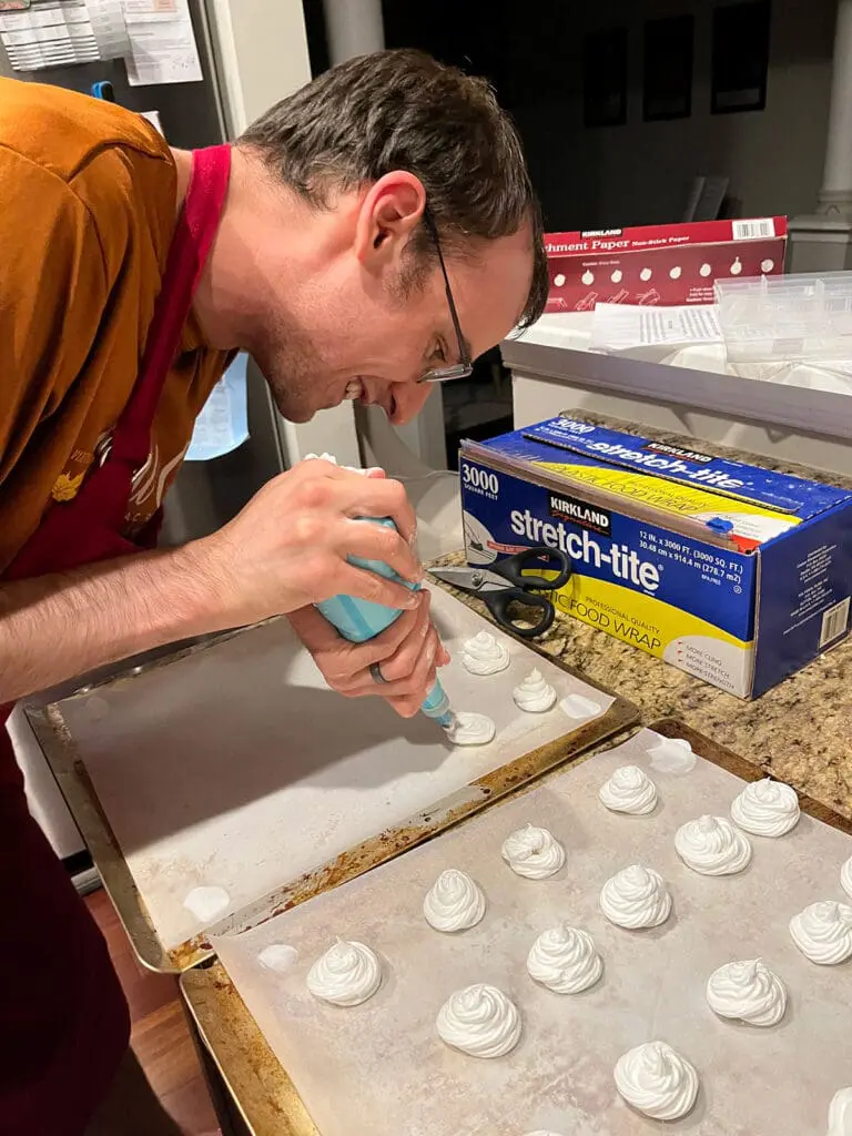 piping pavlovas onto cookie sheet