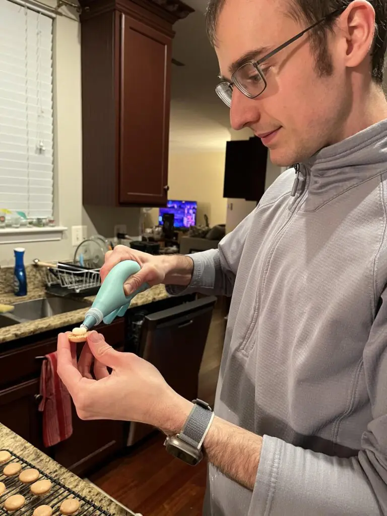 Piping buttercream on macarons