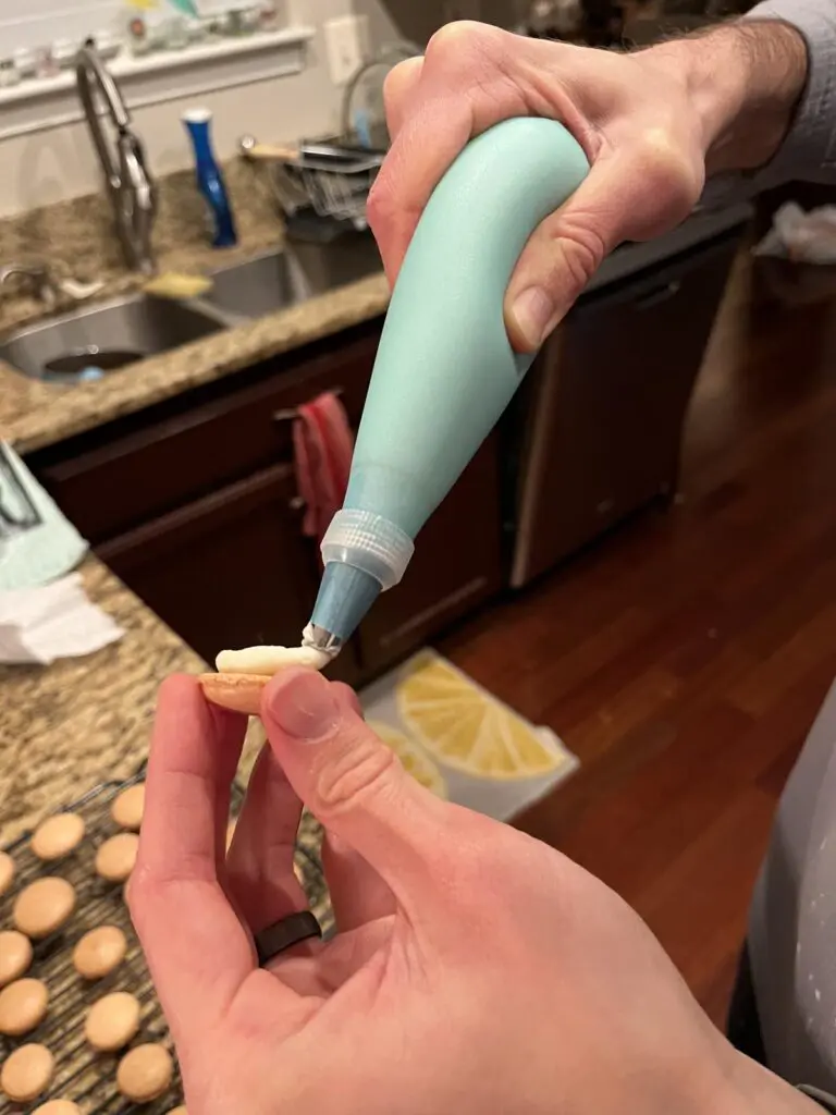 Piping buttercream on macarons