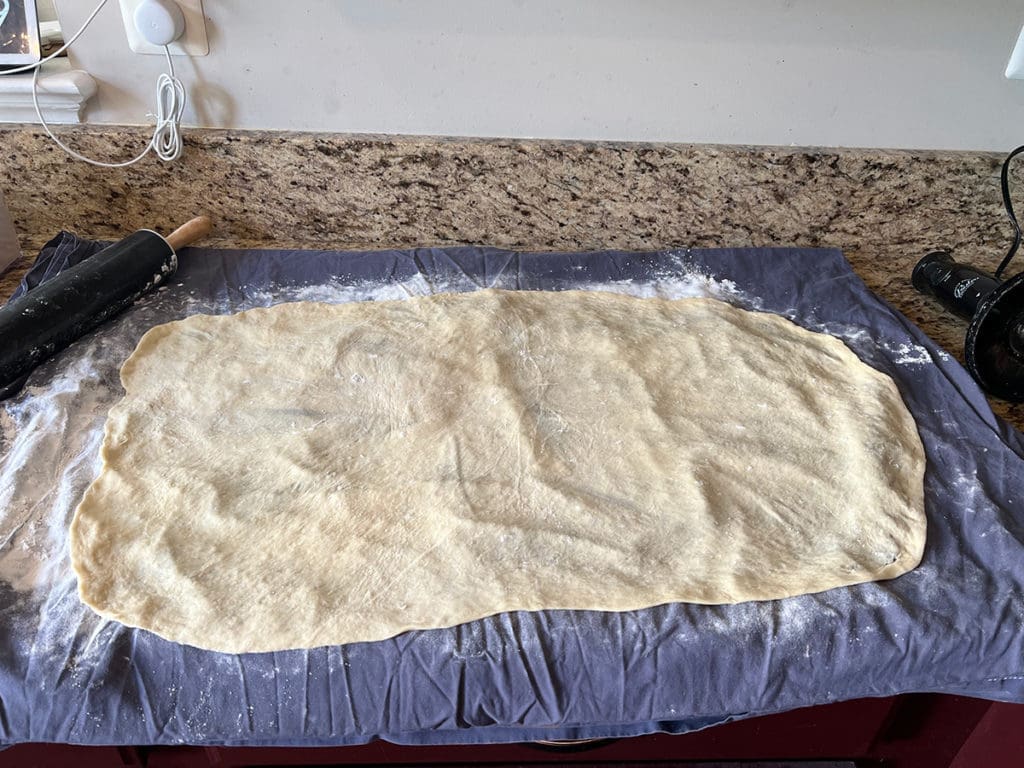 Povitica dough stretched out on bedsheet