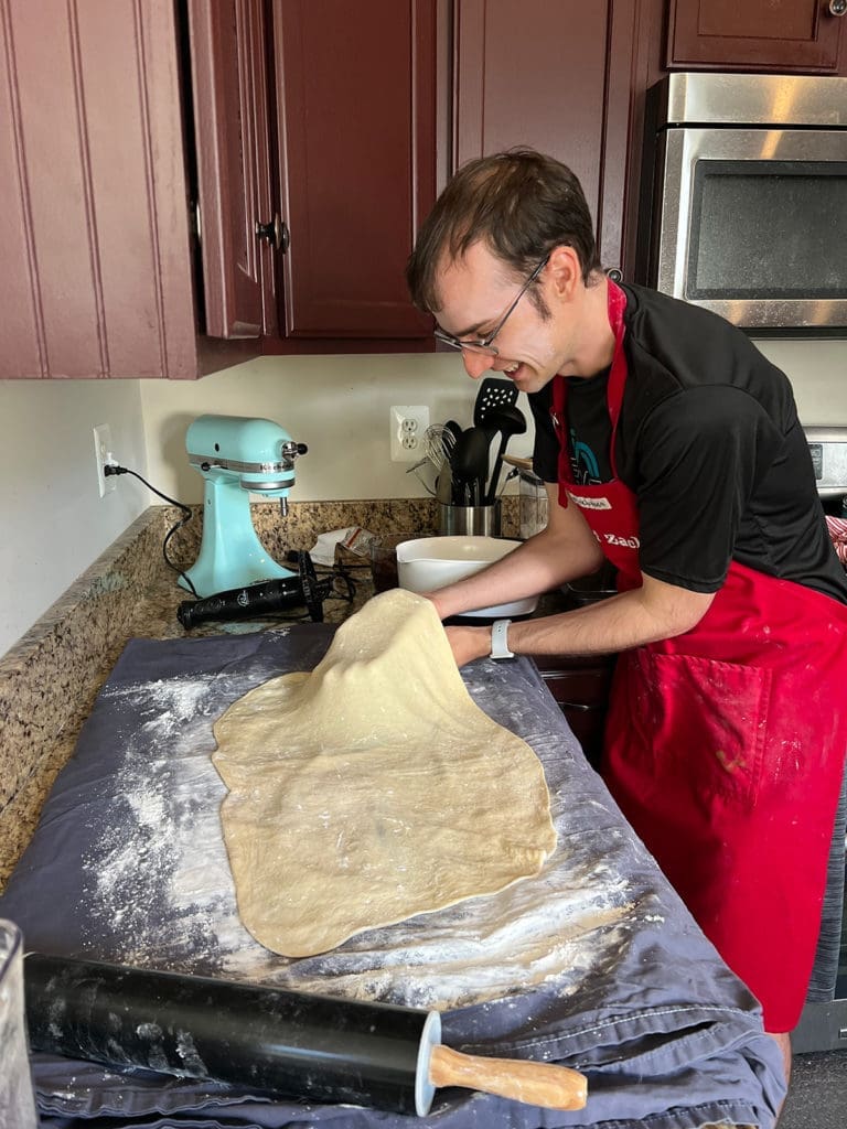 Xak stretching povitica dough on a bedsheet