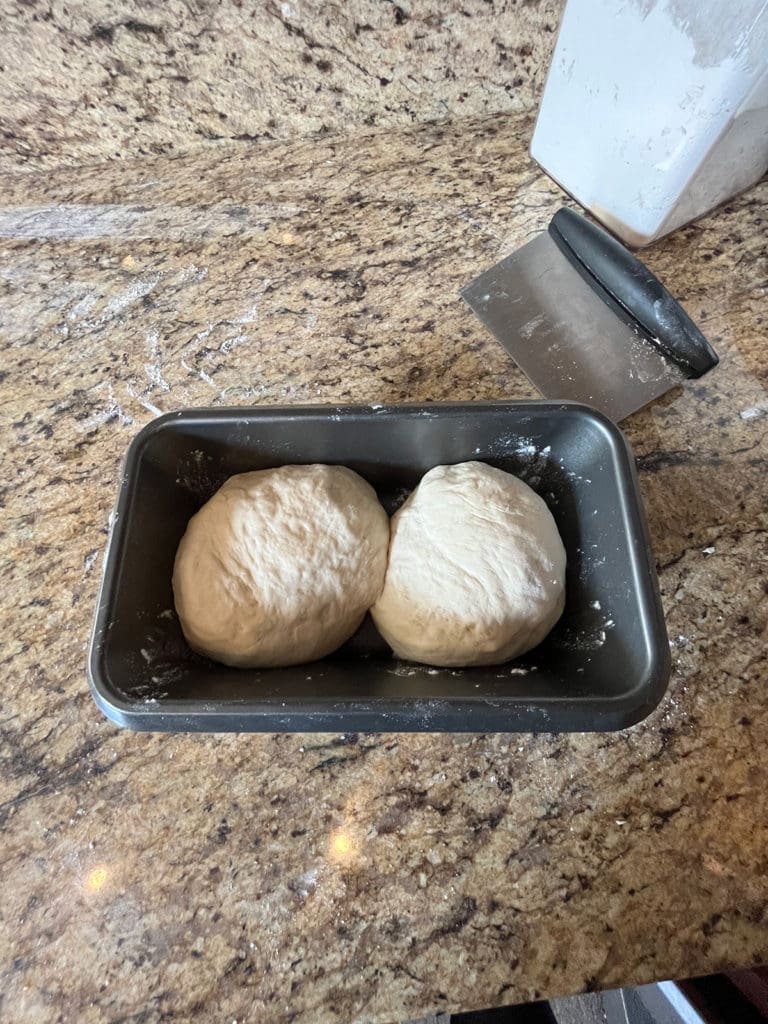 Two buns side by side in a baking pan
