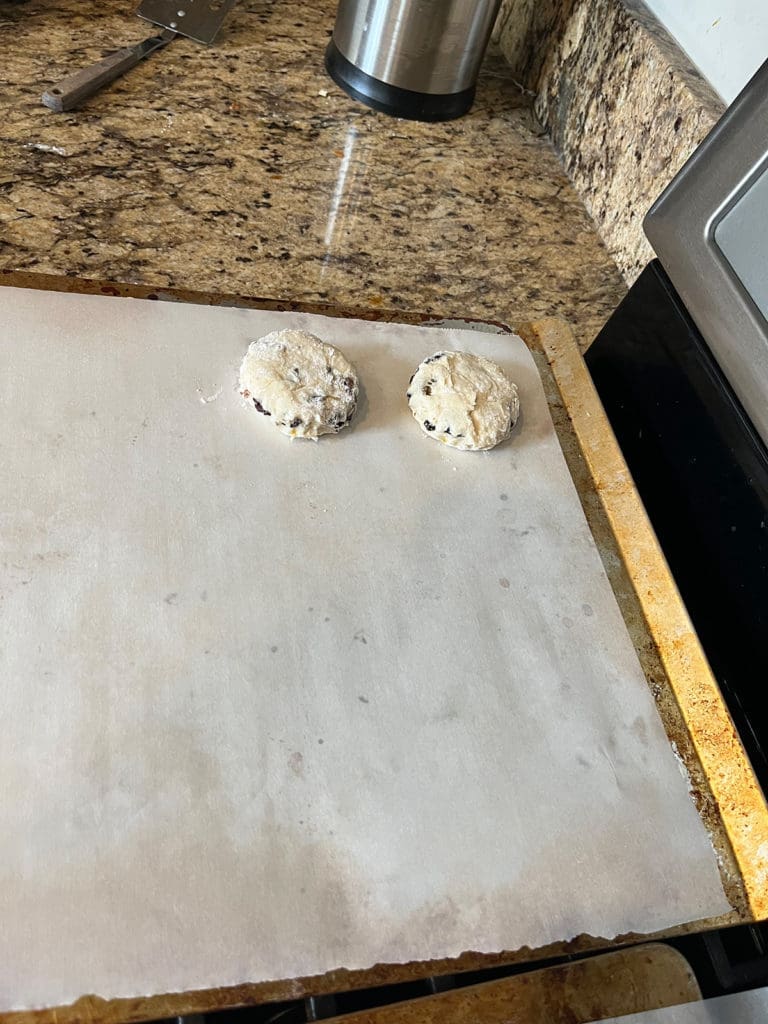 Two unbaked scones side by side on baking sheet